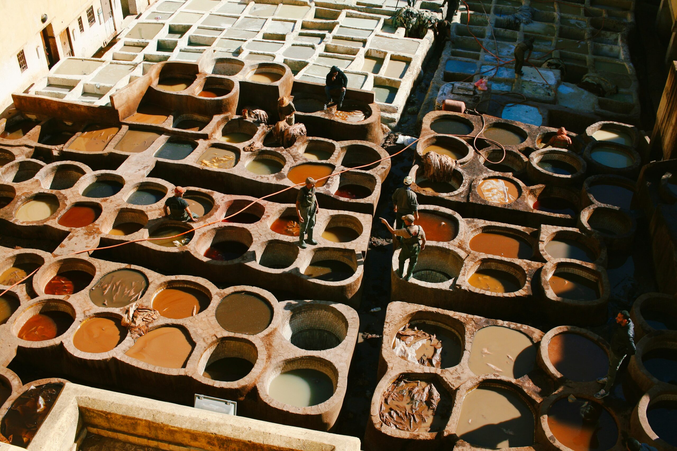 Traditional leather dyeing pits at the Chouara tannery in Fes Medina Morocco during a cultural sightseeing visit